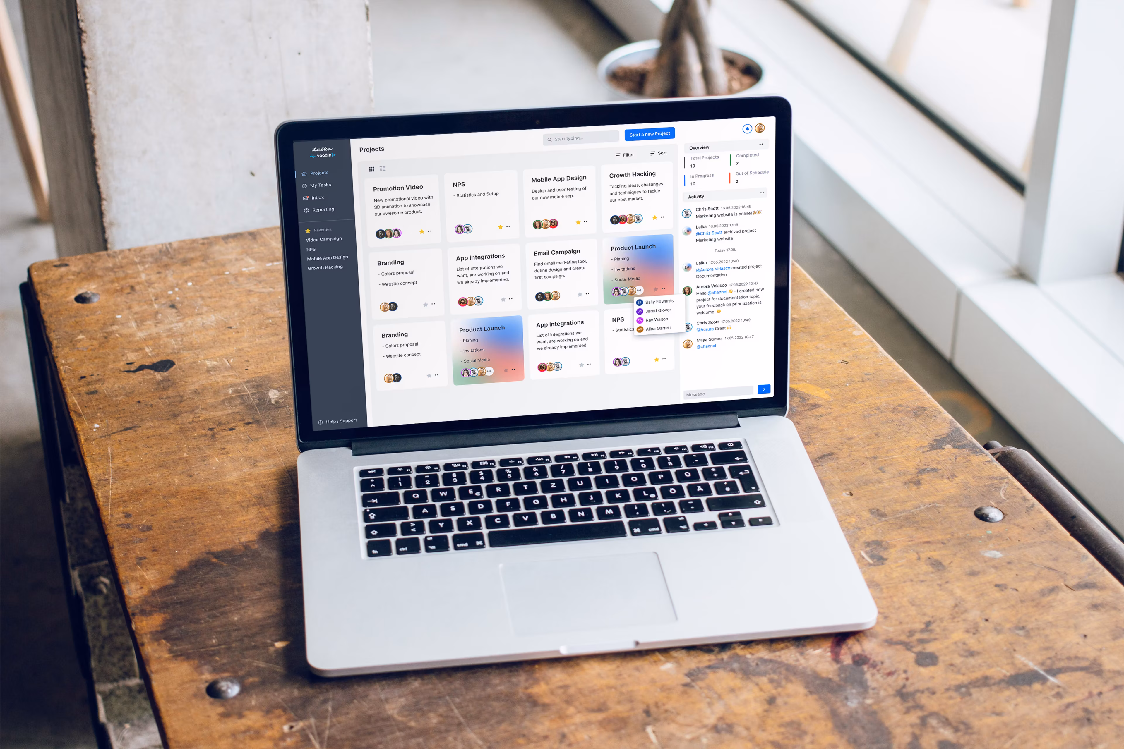A MacBook on a wooden desk displaying the Laika project-management dashboard.